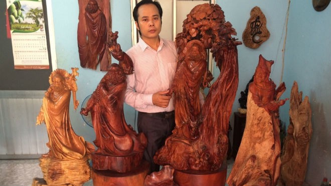 Nghệ nhân Nguyễn Quang Nam bên những tác phẩm tượng gỗ Đạt Ma Sư Tổ