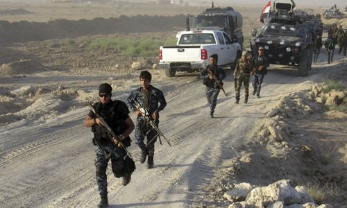 Lực lượng an ninh Iraq cùng dân quân người Shiite và các tay súng bộ tộc Sunni chiếm giữ một cứ điểm bên ngoài Fallujah. Ảnh: AP