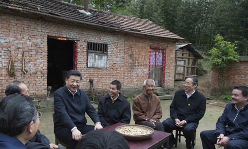 Chủ tịch Trung Quốc Tập Cận Bình mặc chiếc áo gió quen thuộc khi đến thăm một vùng nông thôn. Người nông dân ngồi bên cạnh ông cũng mặc chiếc áo tương tự. Ảnh: Xinhua