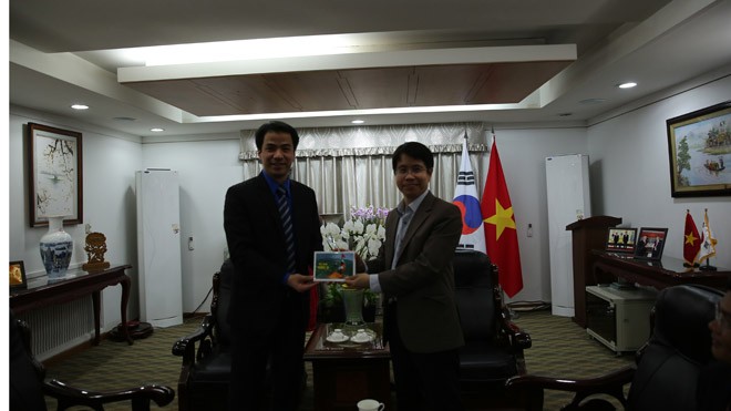 Anh Ngô Văn Cương (bên trái) tặng bưu thiếp “Trường Sa Xanh” cho đại diện Đại sứ quán Việt Nam tại Hàn Quốc.