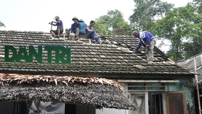 Người dân xã Sơn Trường đang giúp bà Ái sửa lại mái nhà bị sét đánh hỏng.