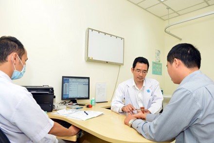 Bác sĩ Thành đang khám cho bệnh nhân bị tê tay do dùng các thiết bị điện tử thời gian dài trong ngày. Ảnh:Khánh Trung.