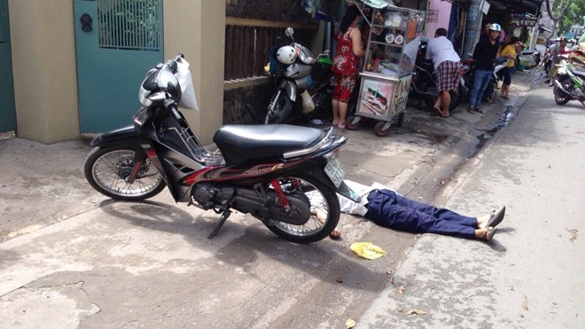 Người đàn ông tử vong cùng chiếc xe gắn máy bên đường.
