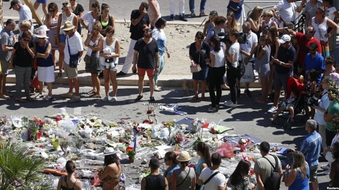 Người dân đứng quanh khu vực đặt hoa tưởng niệm các nạn nhân thiệt mạng trong vụ tấn công khủng bố ở Nice.