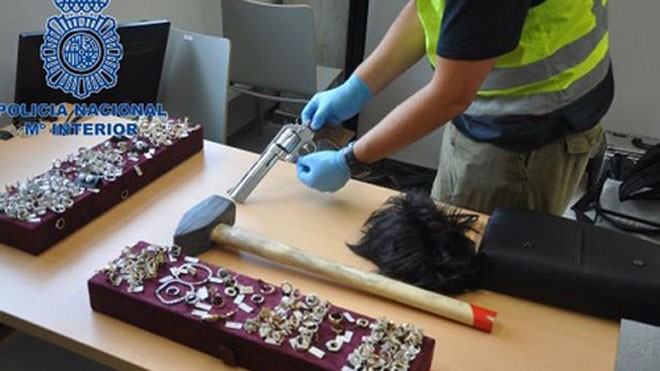 Tóc giả, kính, súng mà những tên trộm sử dụng trong vụ cướp tiệm kim hoàn ở Barcelona. Ảnh: Cảnh sát Tây Ban Nha