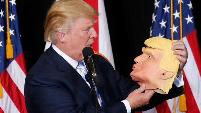 Trump nhìn vào chiếc mặt nạ mô phỏng mình tại buổi vận động tranh cử ở Sarasota, bang Florida hôm 7/11. Ảnh: Reuters. 