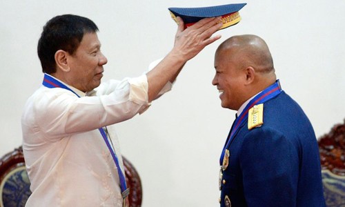 Tổng thống Philippines Rodrigo Duterte đội mũ cho Tư lệnh Cảnh sát Quốc gia Ronald dela Rosa. Ảnh: Inquirer