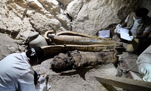 Các nhà khảo cổ khám nghiệm quan tài trong hầm mộ. Ảnh: EPA.
