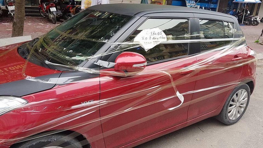 Chiếc xe ô tô bị dán đầy băng keo trên phố Vũ Phạm Hàm. Ảnh: Anh Đức