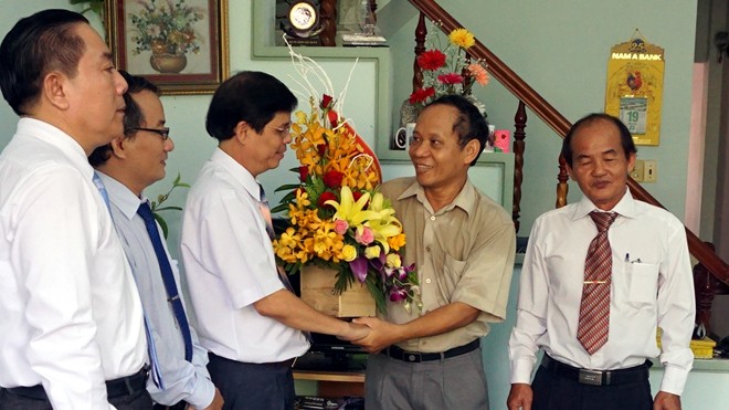 Ông Nguyễn Tấn Tuân tặng bó hoacủa Tỉnh ủy, HĐND, UBND tỉnh Khánh Hòa cho phóng viên báo Tiền Phong