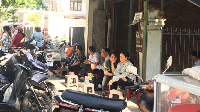 Phụ huynh ngồi đợi con trước một quán cà phê gần điểm thi trường THPT Trần Phú (quận Hải Châu). Ảnh: Thanh Trần. 