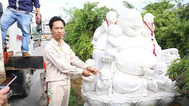 Hoan bên cạnh bức tượng Phật Di Lặc. Ảnh: Công an cung cấp.