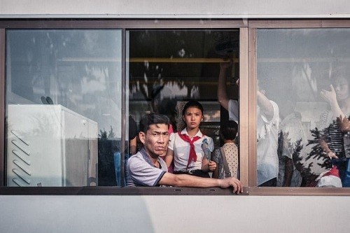 Một người đàn ông Triều Tiên nhìn ra khung cửa sổ xe buýt. Ảnh: Michal Huniewicz.