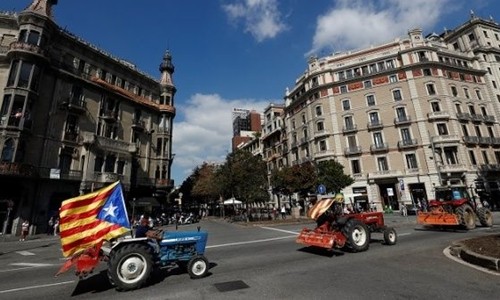 Nông dân lái máy kéo trên đường phố Barcelona ủng hộ Catalonia tách riêng. Ảnh: Reuters