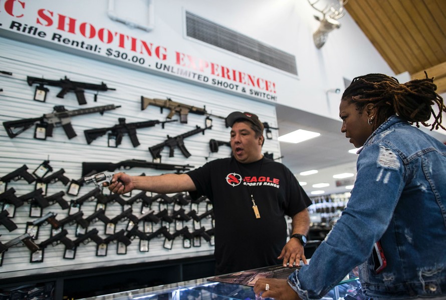 Jason Zielinski tư vấn cho khách hàng chọn mua súng trong cửa hàng Eagle Sports ở Oak Forest, bang Illinois, Mỹ, ngày 16/7. Ảnh: AFP/Getty.