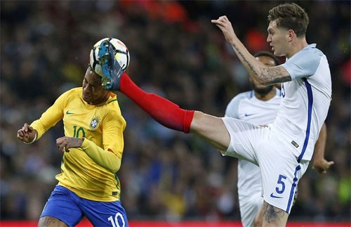 Stones và hàng thủ Anh đứng vững trước các đợt tấn công của Brazil. Ảnh: Reuters