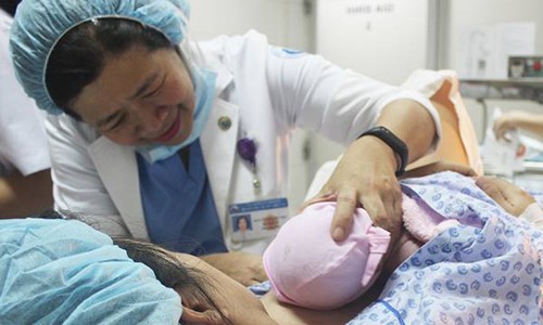 Tại Bệnh viện Từ Dũ, sau khi chào đời, bé được bác sĩ đưa đến "da kề da" một cách tự nhiên với mẹ. Ảnh: Lê Phương.