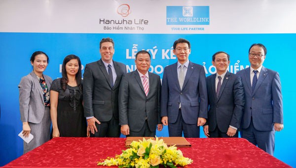 Ông Back Jong Kook (Thứ 3, bìa phải), Chủ tịch Hội đồng thành viên kiêm Tổng giám đốc Hanwha Life Việt Nam, chúc mừng đại diện đối tác Worldlink tại lễ ký kết hợp tác chiến lược ngày 26-7.