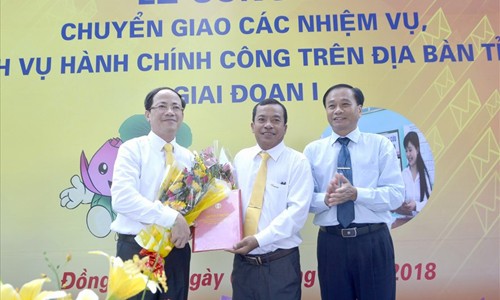 Ông Nguyễn Văn Dương (phải) cùng ông Phạm Anh Tuấn tặng hoa cho đại diện Bưu điện Đồng Tháp trong lễ công bố. Ảnh: Lâm Lý