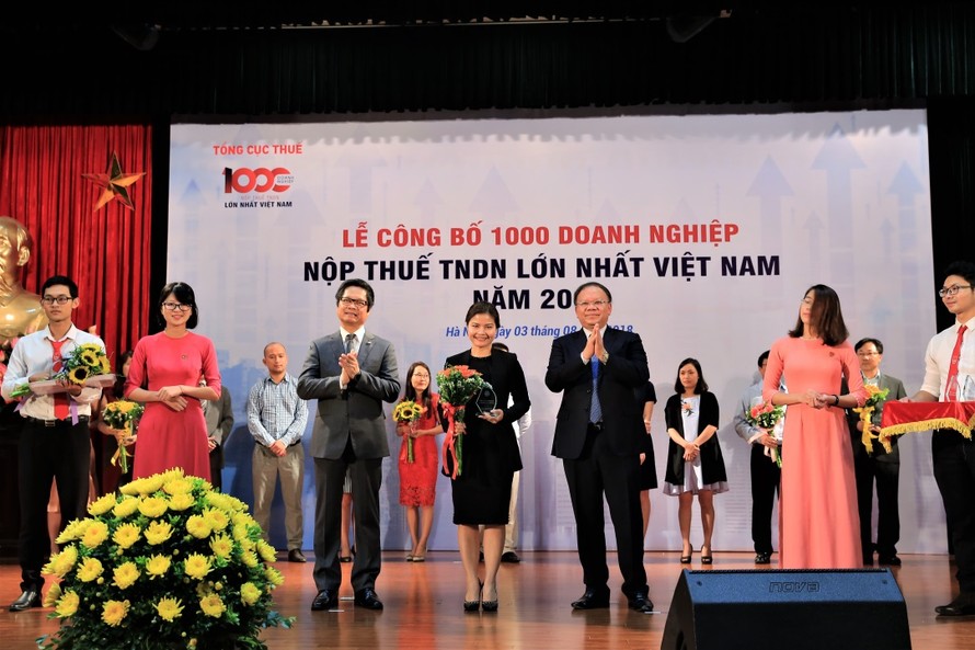 Ông Bùi Văn Nam, Tổng cục trưởng Tổng cục Thuế và Ông Vũ Tiến Lộc, Chủ tịch VCCI trao hoa và kỷ niệm chương cho đại diện công ty TNHH Nestlé Việt Nam tại Lễ Công bố.