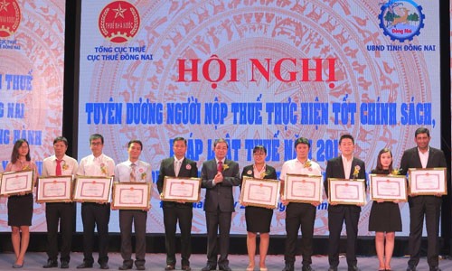 Ông Nguyễn Quốc Hùng, Phó chủ tịch UBND tỉnh Đồng Nai trao bằng khen cho đại diện Nestlé Việt Nam cùng đại diện các doanh nghiệp, cá nhân khác