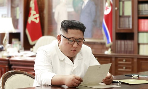 Lãnh đạo Triều Tiên Kim Jong-un đọc thư từ Tổng thống Mỹ Donald Trump tại văn phòng. Ảnh: KCNA.