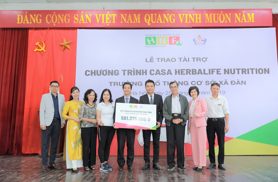 Ông Nguyễn Thành Đạt (thứ 4 từ phải sang) - Giám đốc Truyền thông Herbalife Việt Nam đại diện công ty trao tặng hơn 581 triệu đồng cho trường PTCS Xã Đàn