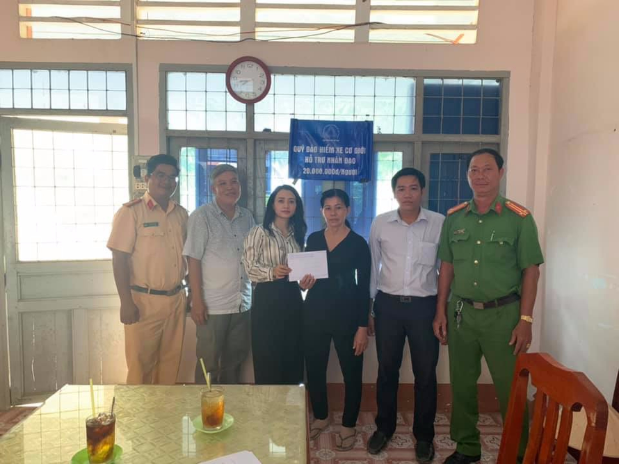 Bà Hoàng Thị Yên (thứ ba từ trái sang), Chánh văn phòng Quỹ Bảo hiểm Xe cơ giới trao hỗ trợ 20 triệu đồng cho người dân ở Đồng Tháp. Ảnh: Quỳnh Vân
