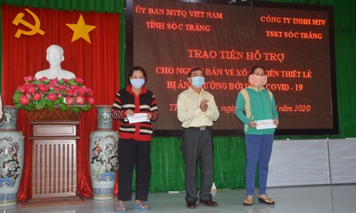 Ông Lê Văn Khannh - Giám đốc Công ty TNHH MTV XSKT Sóc Trăng trao tiền hỗ trợ cho người bán vé số