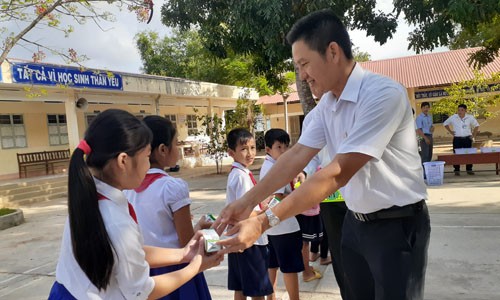 Các thầy cô giáo phát sữa cho các em học sinh nhân ngày đầu tiên bắt đầu uống sữa học đường