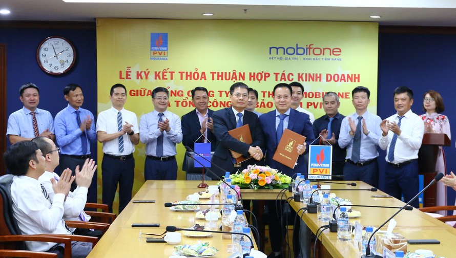 Ông Tô Mạnh Cường, Tổng giám đốc Tổng công ty Viễn thông MobiFone (ở giữa, bên trái) và Ông Phạm Anh Đức, Tổng giám đốc Tổng công ty Bảo hiểm PVI (ở giữa, bên phải) ký kết Thỏa thuận hợp tác