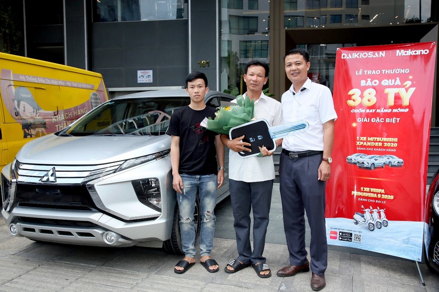 Đại diện công ty Đại Việt (áo trắng bên phải) trao ô tô cho anh Phát (ở giữa)