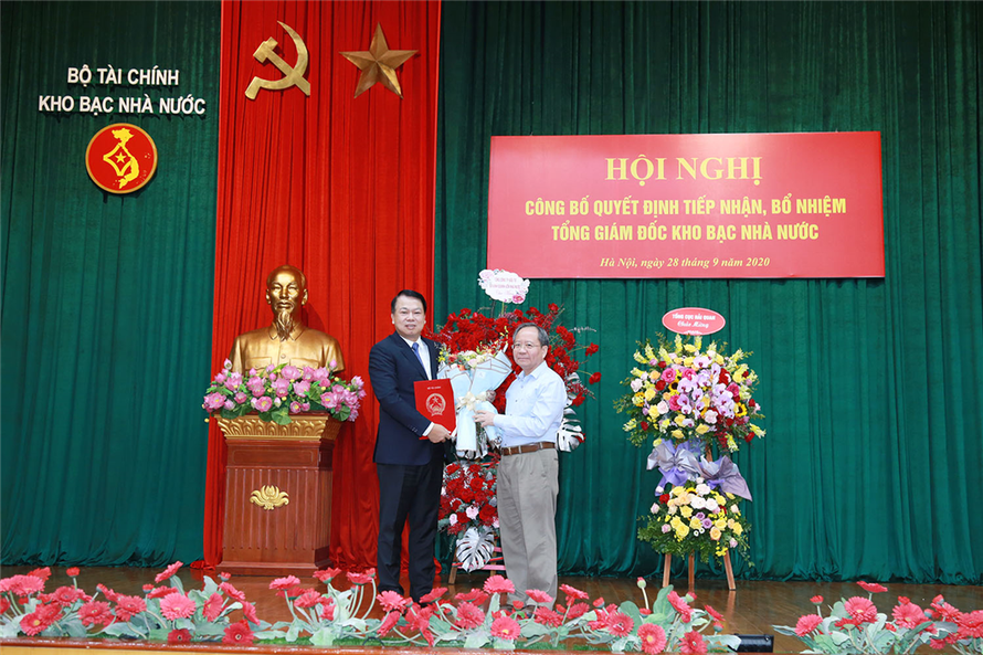 Đồng chí Đỗ Hoàng Anh Tuấn, Ủy viên Ban Cán sự Đảng - Thứ trưởng Bộ Tài chính trao Quyết định, tặng hoa chúc mừng đồng chí tân Tổng Giám đốc KBNN Nguyễn Đức Chi