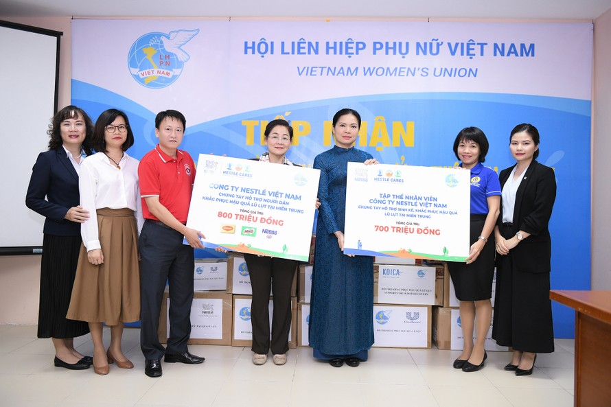Chủ tịch Hội LHPN Việt Nam Hà Thị Nga (áo dài xanh), Phó Chủ tịch Hội Trần Thị Hương (kế bên trái), tiếp nhận phần hỗ trợ từ đại diện công ty Nestlé Việt Nam. 