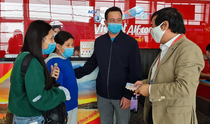 Phó tổng giám đốc Vietjet Nguyễn Đức Thịnh tặng quà một gia đình du xuân trong ngày mùng 1 Tết tại sân bay Nội Bài (ảnh: Đức Minh)