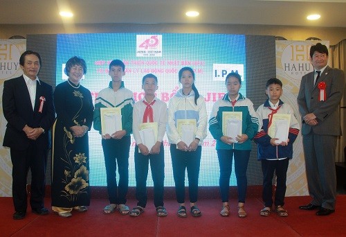 Đại diện JIFA và I.P.M (trái) và đại diện đại sứ quán Nhật Bản tại Việt Nam (phải) chụp ảnh lưu niệm với các em học sinh được trao học bổng 