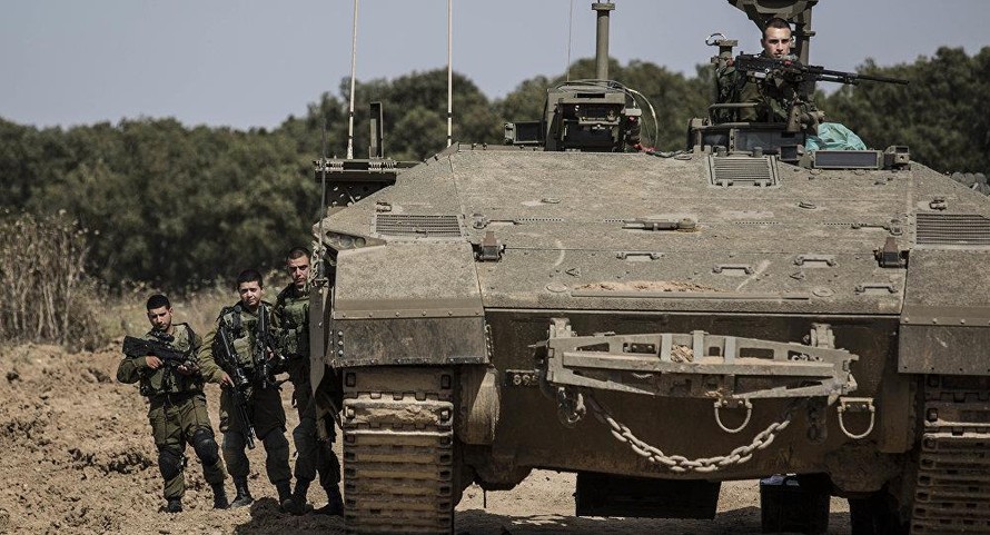 Lính Israel đứng cạnh một chiếc xa tăng gần biên giới Israel Gaza. Ảnh: AP