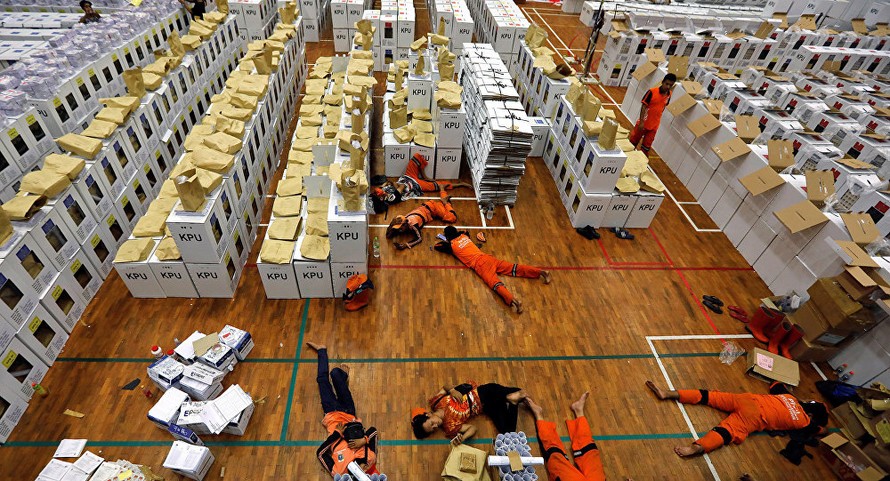 Các nhân viên nằm nghỉ tại chỗ trong giờ giải lao trong khi chuẩn bị tài liệu bầu cử. Ảnh: Reuters