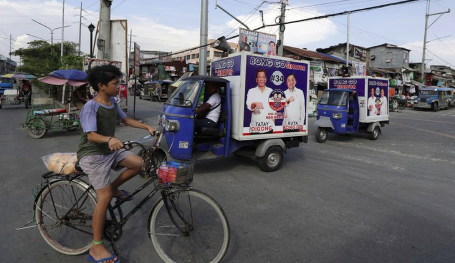 Những chiếc xe dán poster vận động bầu cử chạy quanh quận Tondo hôm 9/5 ảnh: AP 