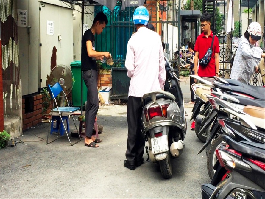 Nhân viên bảo vệ không mặc đồng phục thu 3.000 đồng của người dân tại Công an quận Thanh Xuân Ảnh: Võ Hóa