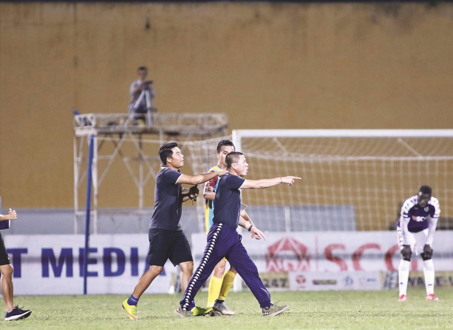 HLV Chu Đình Nghiêm lao vào sân phản ứng trọng tài ngay sau khi trận đấu kết thúc ảnh: VSI