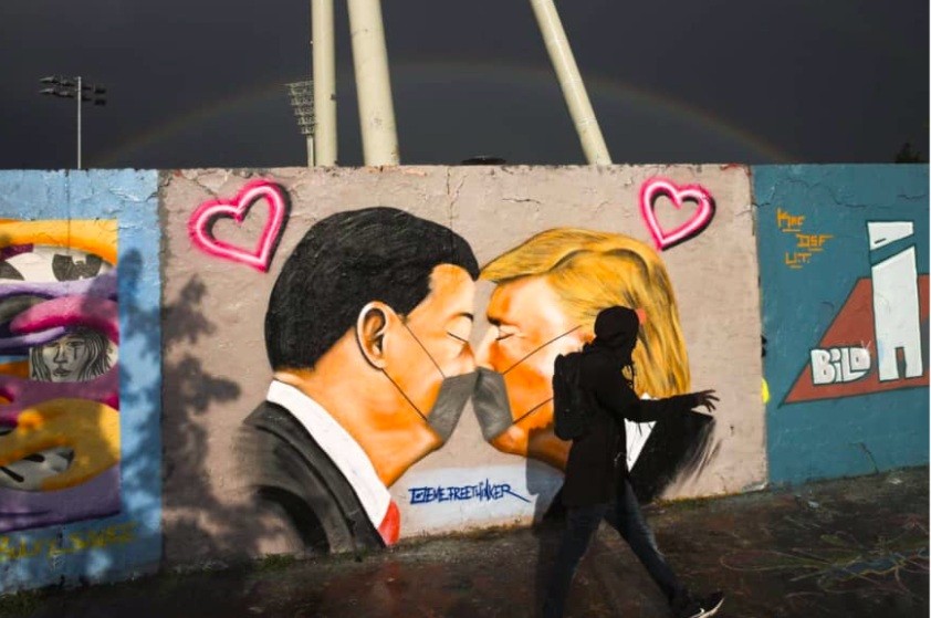 Một người đi qua bức tranh tường ở Berlin vẽ Tổng thống Mỹ Donald Trump và Chủ tịch Trung Quốc Tập Cận Bìnhảnh: AP