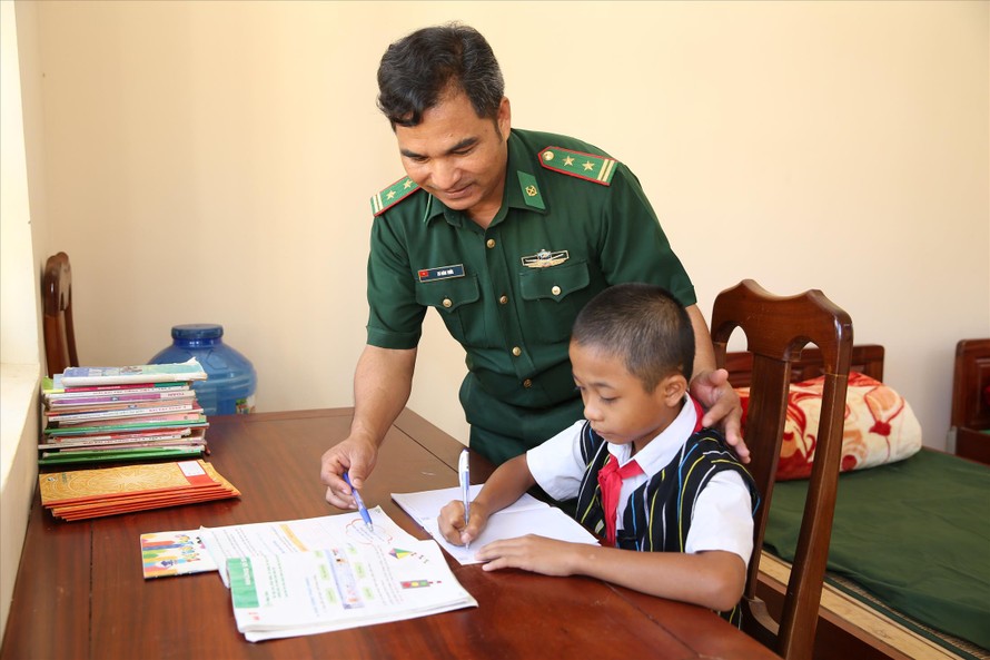Trung tá Zơ Râm Thức, Chính trị viên Đồn Biên phòng cửa khẩu Nam Giang dạy học cho con nuôi Zơ Râm Dũng