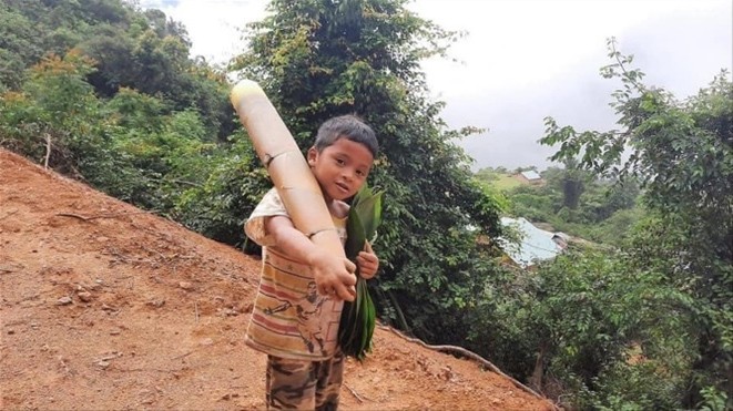 Cậu bé Hồ Ánh Khiết vác búp măng tre lội bộ nửa giờ đồng hồ đến điểm tiếp nhận thực phẩm ủng hộ chống dịch
