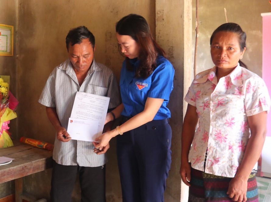 Chị Lê Thị Ngọc Hà trao tặng quyết định truy tặng Huy hiệu dũng cảm cho gia đình em Thoan