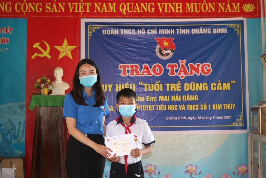 Thừa uỷ quyền của BCH Trung ương Đoàn TNCS Hồ Chí Minh, đại diện Tỉnh đoàn Quảng Bình trao huy hiệu "Tuổi trẻ dũng cảm" cho học sinh Mai Hải Đăng.