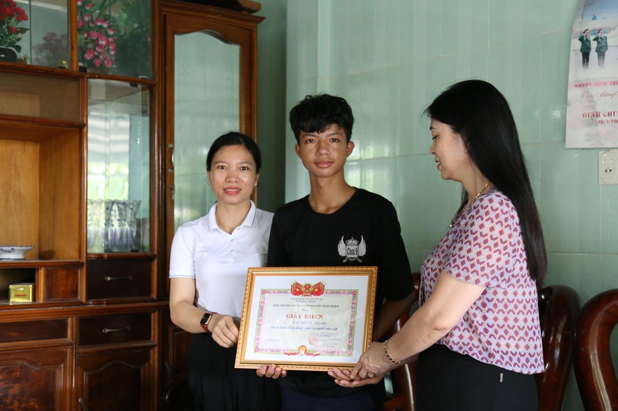 Cô giáo Nguyễn Thị Liên, hiệu trưởng trường THPT Nguyễn Bỉnh Khiêm trao giấy khen cho hành động dũng cảm của học sinh Cao Anh Vũ.
