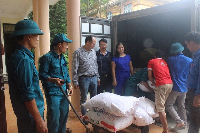 Lãnh đạo Sở Công Thương bàn giao số gạo cho huyện Chương Mỹ tại UBND xã Tân tiến để chuyển đến cho bà con vùng úng ngập.