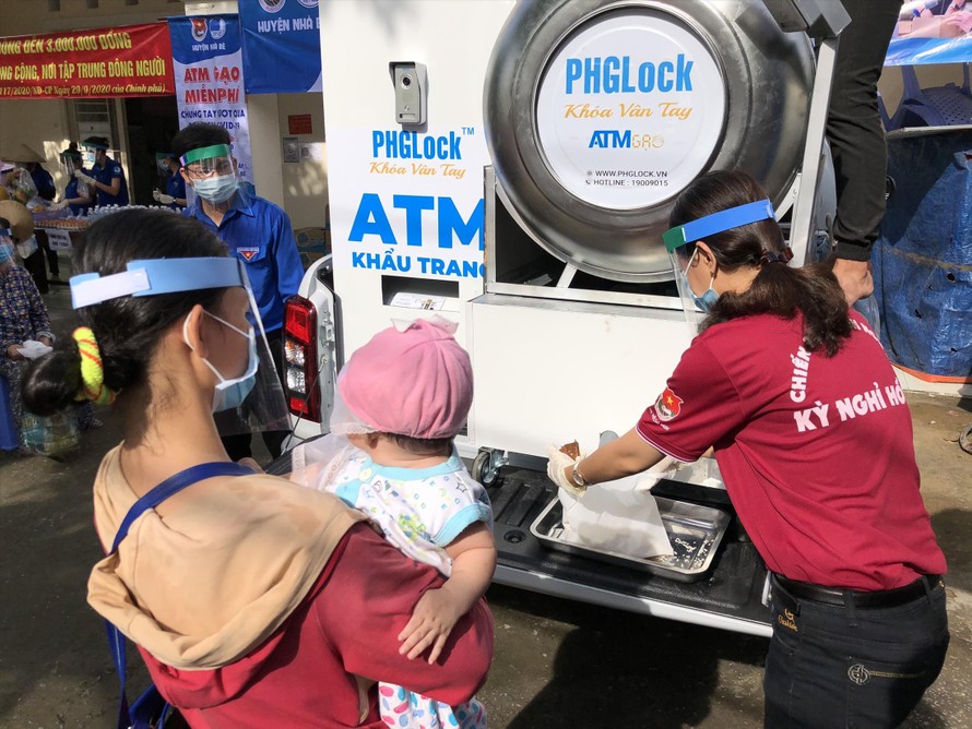 Người dân đến nhận gạo ở ATM gạo lưu động trên chiếc xe bán tải 