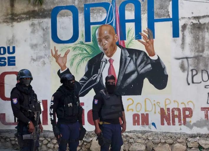 Cảnh sát đứng cạnh bức tranh tường phác họa chân dung Tổng thống Haiti Jovenel Moise gần dinh thự nơi ông bị ám sát ngày 7/7 Ảnh: AP 